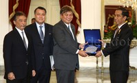 Jokowi dan delegasi FIFA bertukar cenderamata.