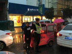 Simpati, Wanita Ini Payungi Polisi yang Bertugas di Tengah Hujan Deras