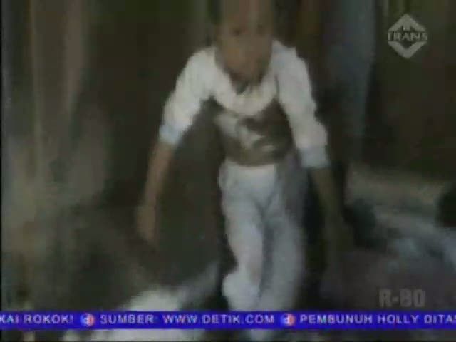 Seorang Guru Menggendong Anak Saat Mengajar
