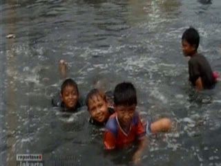 Manfaatkan Banjir, Anak-anak Berenang di Pinggir Jalan