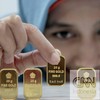 Petugas menunjukan emas 24K 25gram, di kantor BNI Syariah, Jakarta, Senin (8/9).
