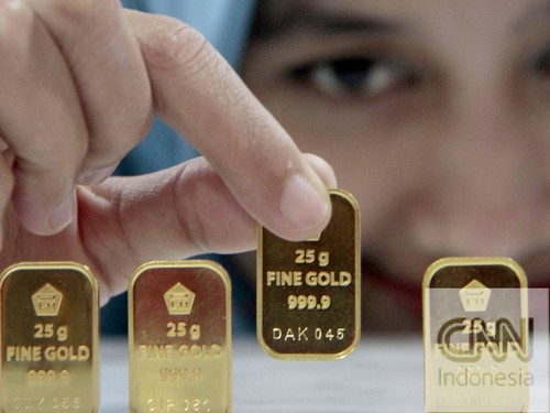 Petugas menunjukan emas 24K 25gram, di kantor BNI Syariah, Jakarta, Senin (8/9).