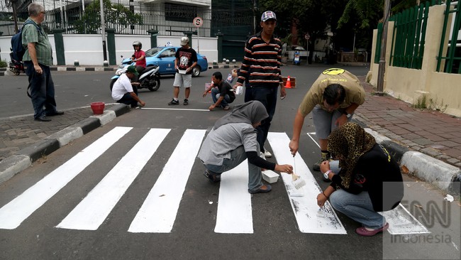Anggota Koalisi Pejalan Kaki mengecat zebra cross ketika menggelar aksi Ruwatan Zebra Cross di Jalan Agus Salim, Sabang, Jakarta, Minggu, 28 September 2014. Aksi tersebut untuk menyerukan kepada pengendara agar menghormati hak pejalan kaki. CNN Indonesia/Safir Makki