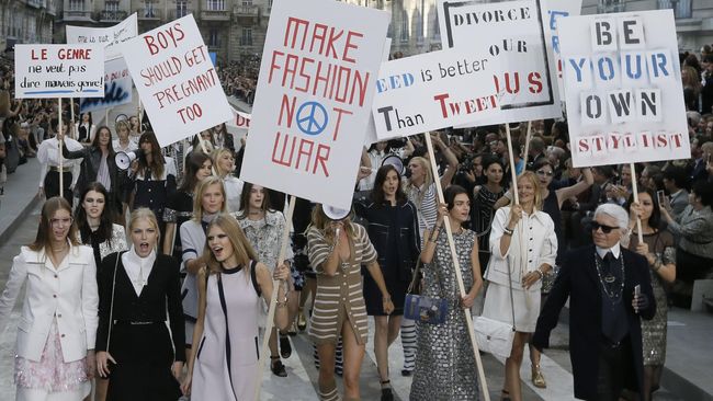 Panggung Paris Fashion Week dipenuhi spanduk yang bertuliskan Ladies First, History is Her Story, We Can Match the Machos dan Boys Should Get Pregnant Too?
