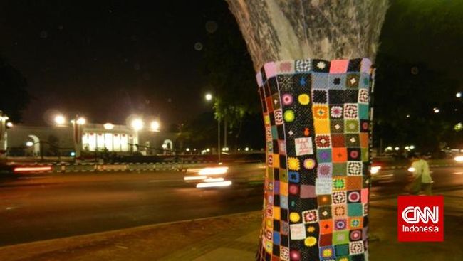 Aksi yarn bombing yang marak di Barat, juga hadir di Jakarta. Kali ini, yang dibungkus rangkaian rajutan adalah pohon di seberang Istana Merdeka.