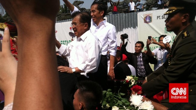 Warga antusias menanti arak-arakan Jokowi-JK di sepanjang jalan utama Jakarta. Melihat parade drum band muncul, larangan mendekat pun tak diacuhkan.