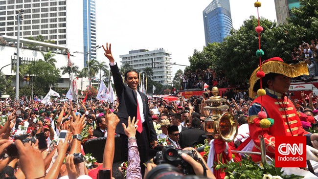 Presiden Jokowi akhirnya naik ke delman yang akan membawanya dari bundaran Hotel Indonesia ke Istana Negara. Warga mengelu-elukannya.