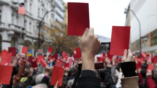 Demonstran velvet membawa kartu merah dalam memperingati 25 tahun Revolusi Velvet, memprotes Presiden Zeman yang dianggap terlalu dekat dengan Rusia.