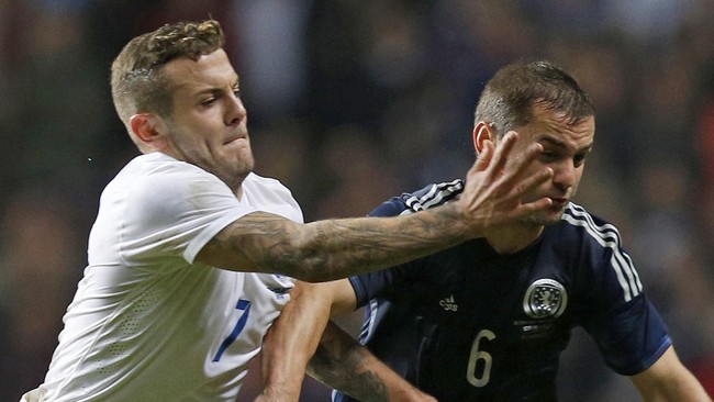 Gelandang Inggris Jack Wilshere menggunakan penyuara kuping (earphone) untuk menghindari gema pendukung Skotlandia di Celtic Park, Rabu (19/11) dini hari WIB.