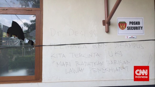 Serpihan kaca berserakan di lantai. Pos keamanan dan koperasi yang dirusak orang tak dikenal dipasangi tali rafia hitam. Semalam, ganja ditemukan di kampus UKI.