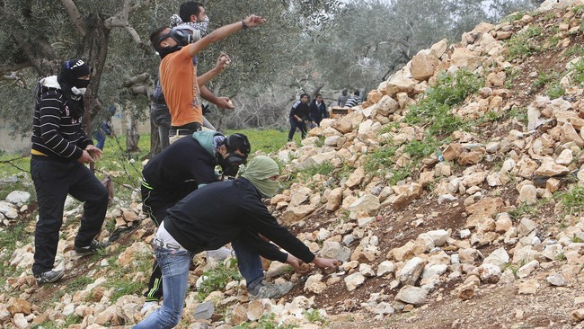 Dalam sebuah foto yang viral di internet, seorang polisi wanita terlihat tengah dilindungi oleh dua pria Palestina dari para pelempar batu.