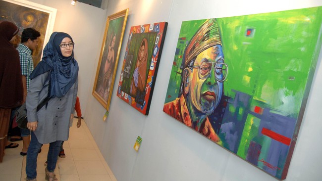 Seorang perempuan mengamati karya seni lukis bergambar presiden Republik Indonesia ke-4, Abdurrahman Wahid atau Gus Dur disela-sela festival seni di Kantor PWNU Jatim, Surabaya, Minggu (21/12). Pameran seni lukis dalam festival seni yang bertajuk 
