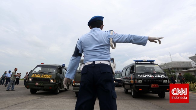 Petugas gabungan memasukan dua belas jenazah korban pesawat AirAsia QZ8501 yang diturunkan dari pesawat Hercules kedalam ambulans di Base Ops Pangkalan Udara TNI Angkatan Laut Juanda, Surabaya, Jawa Timur, Sabtu, 3 Januari 2014. CNN Indonesia/Adhi Wicaksono.