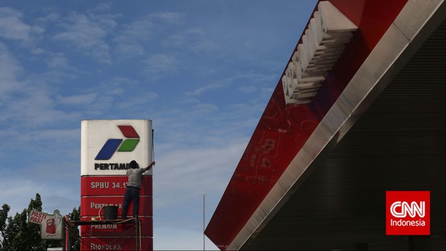 Pekerja membersihkan logo Pertamina di salah satu SPBU, kawasan Pasar Minggu, Jakarta, Sabtu, 10 Januari 2015. CNN indonesia/Adhi Wicaksono.