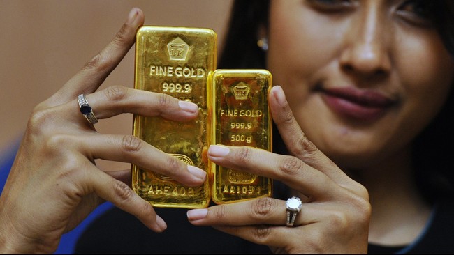 Seorang petugas memperlihatkan emas batangan produksi PT Antam di Jakarta, Senin (19/1). Harga jual emas Antam  tercatat Rp 553.000 per gram atau meningkat Rp 28.000 per gram dibandingkan perdagangan pada awal tahun sebesar Rp 525.000 per gram. ANTARA FOTO/Wahyu Putro A/ss/ama/15