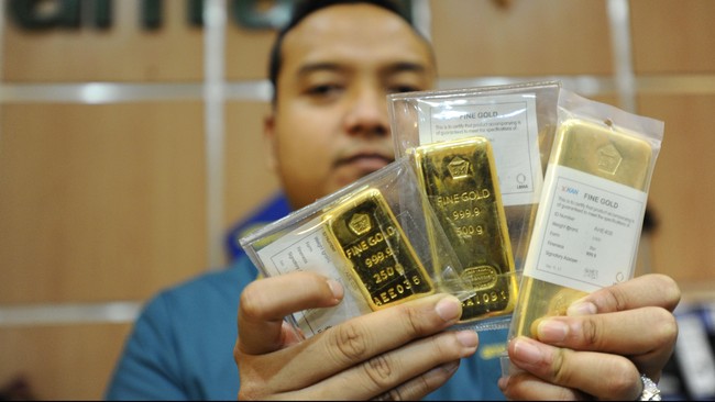 Seorang petugas memperlihatkan emas batangan produksi PT Antam di Jakarta, Senin (19/1). Harga jual emas Antam  tercatat Rp 553.000 per gram atau meningkat Rp 28.000 per gram dibandingkan perdagangan pada awal tahun sebesar Rp 525.000 per gram. ANTARA FOTO/Wahyu Putro A/ss/ama/15
