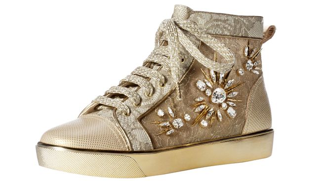 Sebuah sneakers high-top yang dihiasi dengan renda emas dan hiasan batu permata di sisinya.