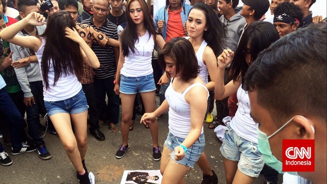 Para penari seksi menari sambil menginjak-injak gambar wajah pimpinan KPK Abraham Samad-Bambang Widjojanto, serta petinggi Polri Budi Gunawan-Budi Waseso.