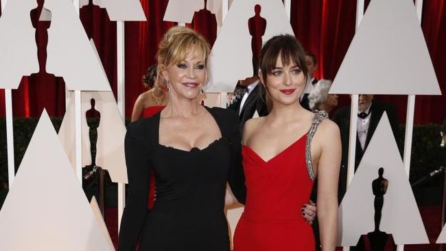 Bintang yang tengah melejit dengan film Fifty Shades of Grey, Dakota Johnson tampil dengan gaun merah terang dari Saint Laurent.