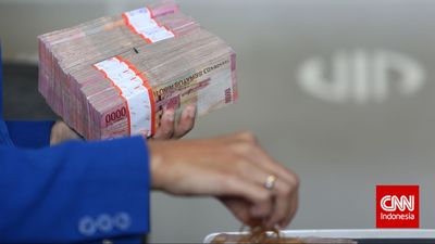 Kasir memegang tumpukan uang rupiah di tempat penukaran uang di kawasan Cikini, Jakarta, Selasa, 10 Maret 2015. Nilai tukar rupiah dalam transaksi antarbank di Jakarta pada Selasa (10 /03/2015) pagi t