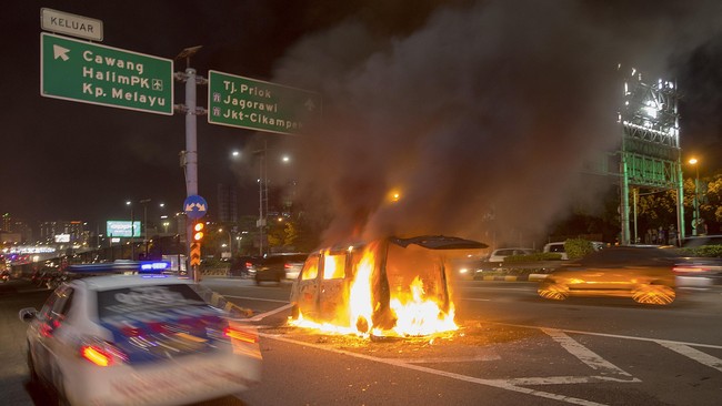 Sebuah mobil Daihatsu Luxio terbakar di pintu keluar Tol Cawang, Jakarta Selatan, Selasa (10/3) malam. Peristiwa yang diduga akibat hubungan listrik arus pendek tersebut tidak menelan korban jiwa namun menyebabkan kemacetan arus lalu lintas di ruas tol dalam kota arah Jagorawi maupun di arteri Jalan M.T. Haryono. ANTARA FOTO/Widodo S. Jusuf/Asf/Spt/15.
