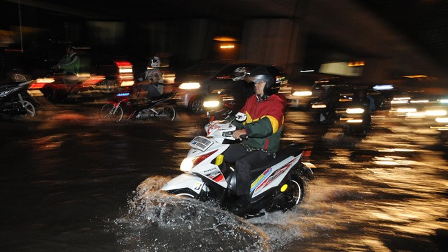 Penyebab air lama surut saat diterjang hujan dan pasang air laut karena belum selesainya pembangunan tanggul di utara Jakarta.