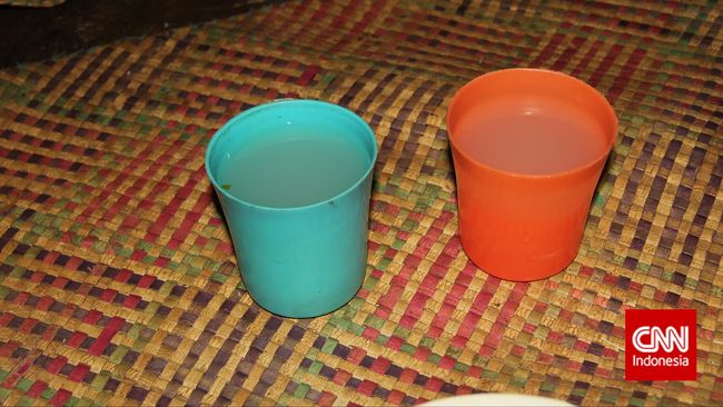 Seorang pemuda membawakan gelas dan minuman di botol berwarna hijau, dia berikan kepada tamu dan orang-orang terhormat di situ.