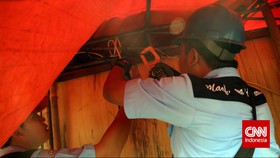 Petugas PLN melakukan penertiban aliran listrik liar, di kawasan Johar Baru, Jakarta, Rabu, 25 Maret 2015. Penertiban tersebut guna menghindari potensi kebakaran akibat korsleting pada sambungan liar tersebut. CNN Indonesia/Adhi Wicaksono.