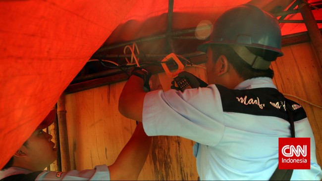 Petugas PLN melakukan penertiban aliran listrik liar, di kawasan Johar Baru, Jakarta, Rabu, 25 Maret 2015. Penertiban tersebut guna menghindari potensi kebakaran akibat korsleting pada sambungan liar tersebut. CNN Indonesia/Adhi Wicaksono.