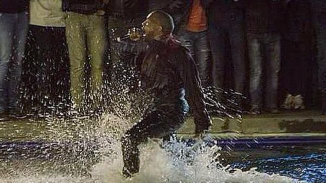Kanye yang terlihat memakai jaket, kaus, jeans dan boots melompat ke dalam danau setelah menyanyikan enam lagu.