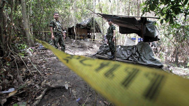 Kuburan massal dan sebuah tempat yang diduga merupakan kamp penahanan korban perdagangan manusia ditemukan oleh polisi Malaysia, pada Ahad (24/5).