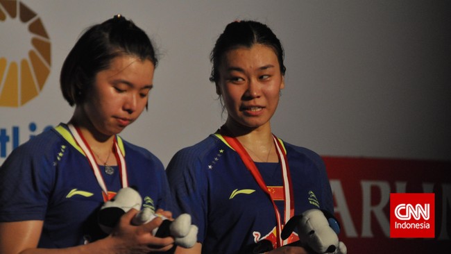 Dua insiden menimpa Tian Qing pada gelaran Indonesia Terbuka 2015. Namun, pasangan ganda putrinya, Tang Jinhua, hanya tertawa saja.