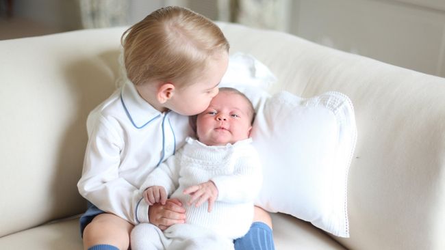 Dalam salah satu foto, Pangeran George yang baru berusia akan berusia dua tahun Juli mendatang terlihat ragu-ragu memangku adiknya.