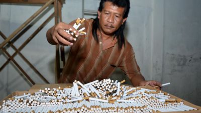 Petugas menunjukkan barang bukti rokok ilegal di pabrik rokok ilegal di Sidoarjo, Jawa Timur, Kamis (11/6) malam. Dalam pabrik rokok yang berkedok usaha pembuatan kerupuk itu petugas gabungan dari Sat