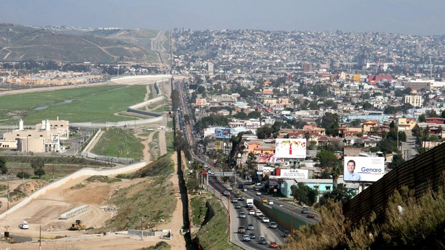 A small fence separates densely populated Tijuana, Mexico, right, from the United States in the Border Patrols San Diego Sector.  Construction is underway to extend a secondary fence over the top of this hill and eventually to the Pacific Ocean.