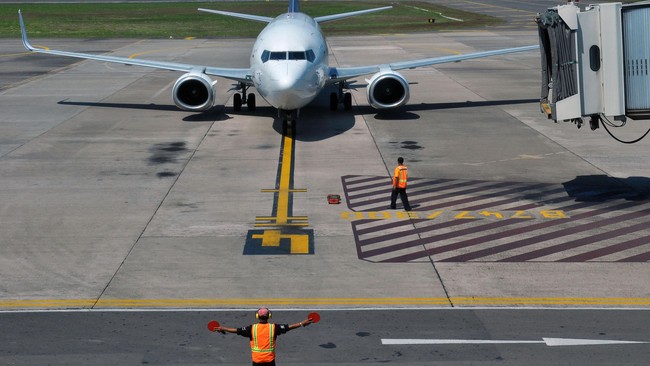 Petugas mengarahkan pesawat komersil untuk parkir di Bandara Adi Soemarmo, Boyolali, Jawa Tengah, Selasa (30/6).  PT. Angkasa Pura I, Bandara Adi Soemarmo berencana akan menambahkan jadwal penerbangan dari biasanya hanya 2100 menjadi 3000 jadwal penerbangan untuk mengantisipasi extra flight mudik lebaran 2015. ANTARA FOTO/ Aloysius Jarot Nugroho/ss/foc/15.