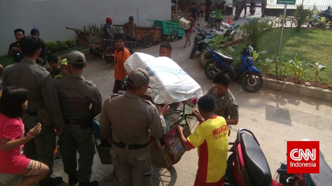 Satu-persatu warga Kampung Pulo mengangkut barang-barangnya ke Rusun Jatinegara Barat. Di Rusunawa, Satpol PP menunggu membantu kedatangan mereka.