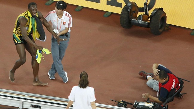 Usain Bolt tak terkejar di lintasan lari, namun ia dengan mudah dijatuhkan oleh seorang juru kamera begitu perlombaan usai.