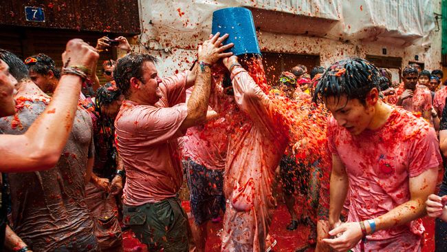 Kota Bunol di timur Spanyol berlumuran cairan merah. Bukan darah, tapi akibat perang lempar tomat yang telah menjadi tradisi tahunan sejak tujuh dekade silam.