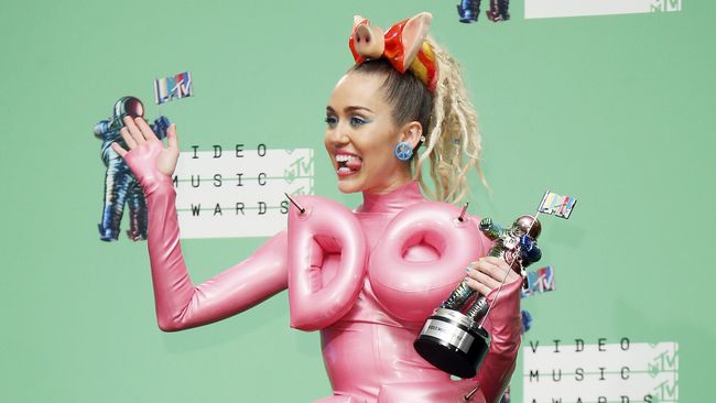 Miley Cyrus lebih ingin menonjolkan belahan dada daripada memamerkan sepucuk pistol seperti Taylor Swift di video musik Bad Blood.