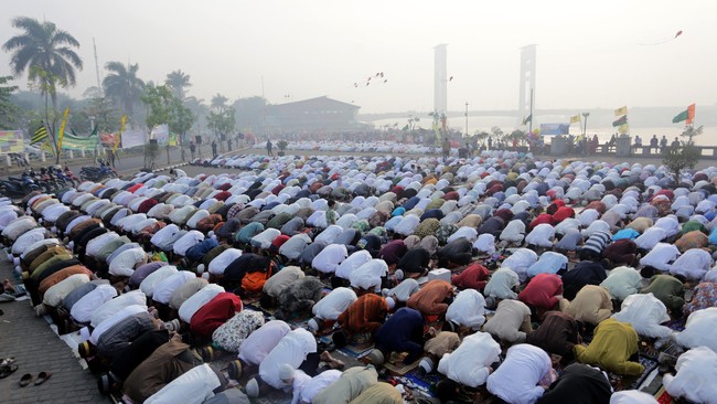 Ribuan warga Muhammadiyah melaksanakan salat Idul Adha di Pelataran Benteng Kuto Besak (BKB) dengan latar belakang jembatan Ampera yang diselimuti kabut asap di Palembang, Sumsel, Rabu (23/9). Sebagian umat muslim di Indonesia merayakan Idul Adha pada Rabu (23/9). ANTARA FOTO/Nova Wahyudi/pras/15
