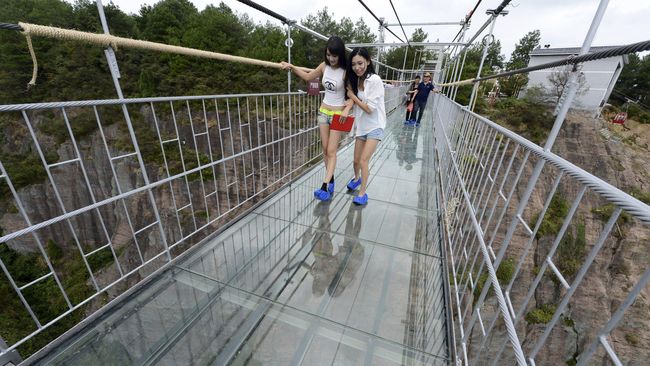 Jembatan yang ada di China ini memang menantang keberanian orang untuk melewatinya. Melintasi  jurang nan curam, jembatan itu terbuat dari kaca.