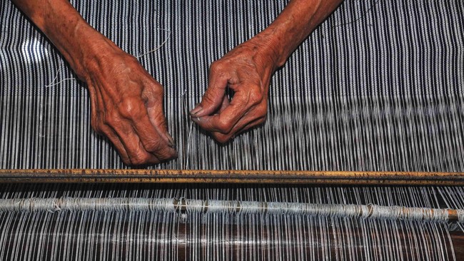 Perajin menyelesaikan proses pembuatan lurik dengan cara di pangku di Desa Jambakan, Bayat, Klaten, Jawa Tengah, Rabu (21/10). Tenun lurik yang dibuat secara tradisional tersebut dijual dengan harga Rp15 ribu hingga Rp30 ribu per meter tergantung kualitas dan kesulitan proses pembuatan. ANTARA FOTO/ Aloysius Jarot Nugroho/kye/15.
