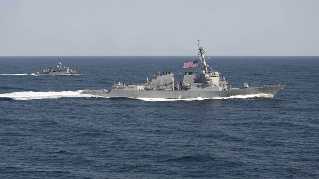 Kapal perang China membuntuti dan memberi peringatan kepada armada tempur laut Amerika Serikat yang menyambangi wilayah sengketa di Laut China Selatan.