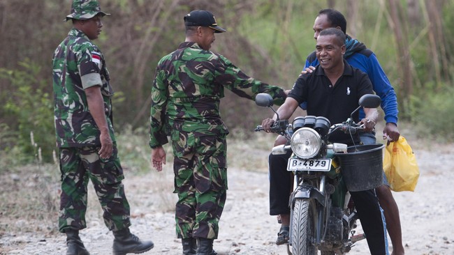 Anggota Satuan Tugas Pengamanan Perbatasan (Satgas Pamtas) RI-Timor Leste berbicang dengan warga Timor Leste di daerah perbatasan Tanubibi, Timor Leste.