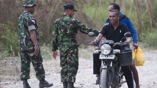 POS PERBATASAN INDONESIA-TIMOR LESTE Anggota Satuan Tugas Pengamanan Perbatasan (Satgas Pamtas) RI-Timor Leste berbicang dengan warga Timor Leste di daerah perbatasan Tanubibi, Timor Leste.