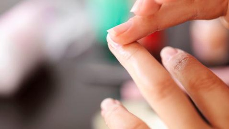 Woman applying lotion to cuticles