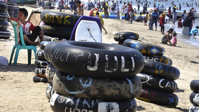 Wisatawan memanfaatkan libur tahun baru dengan berenang di Pantai Pasir Putih, Anyer, Serang, Banten, Jumat (1/1). Ratusan ribu pengunjung menyerbu kawasan wisata pesisir Barat Banten untuk mengisi libur Natal dan Tahun Baru 2016. ANTARA FOTO/Asep Fathulrahman/nz/16