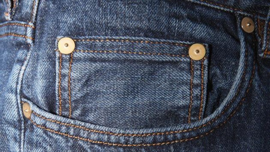denim Close-up on the front pockets of a blue jeans