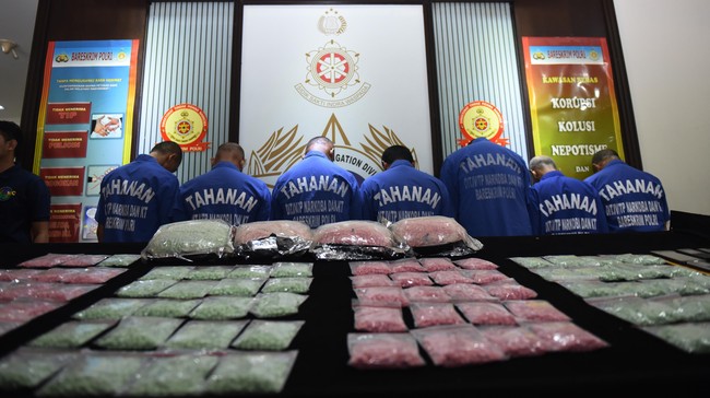 Petugas kepolisian menghadirkan tersangka dan menunjukkan barang bukti narkoba saat gelar perkara jaringan narkoba Malaysia-Indonesia di Jakarta, Jumat (19/2). Direktorat Tindak Pidana Naroba Bareskrim Polri berhasil mengungkap sindikat narkoba jenis ekstasi jaringan Malaysia-Indonesia dengan mengamankan tujuh tersangka dan 40 ribu butir ekstasi senilai Rp24 miliar.  ANTARA FOTO/Hafidz Mubarak A./ama/16